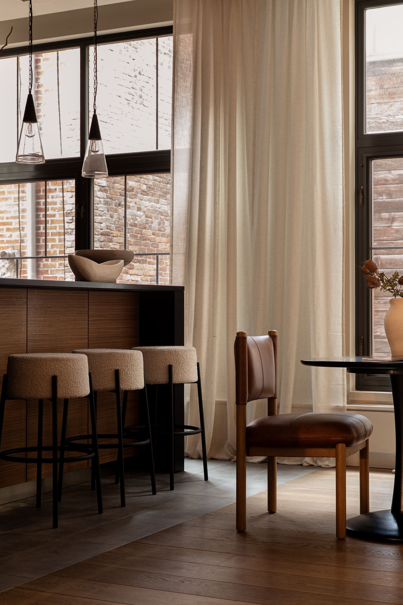 Kitchen island with bouclé stools and a breakfast table at 55 Warren Street, Tribeca, staged by Stage One